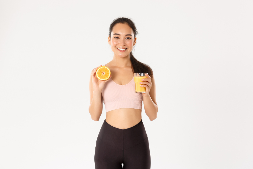 Girl drinking Orange Juice and holding an orange