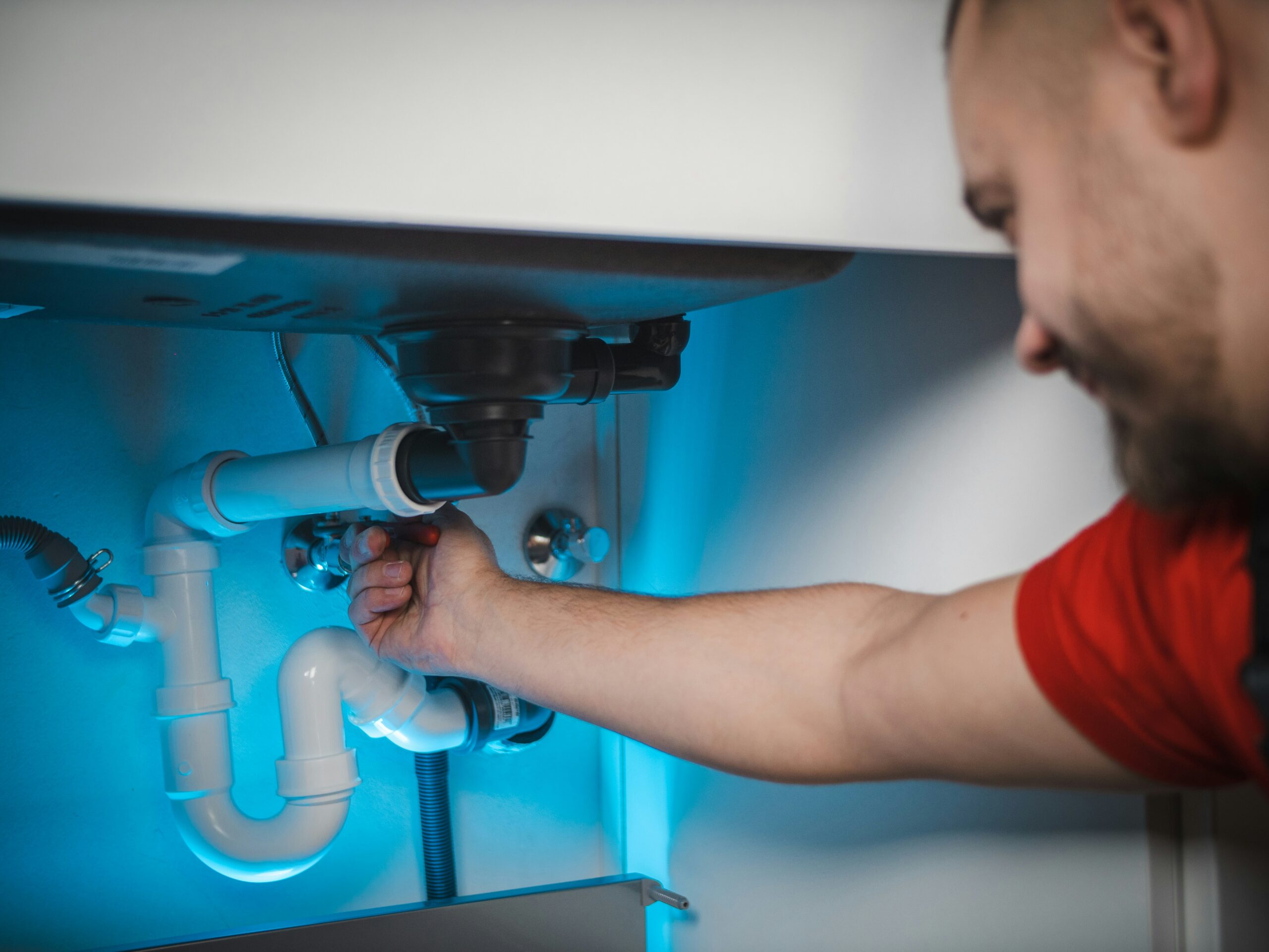 A man fixing pipe leakage and doing plumbing service